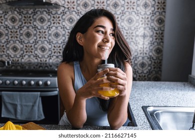 Hispanic Brunette Young Latin Woman Drinking Orange Juice At The Kitchen In Mexico Latin America