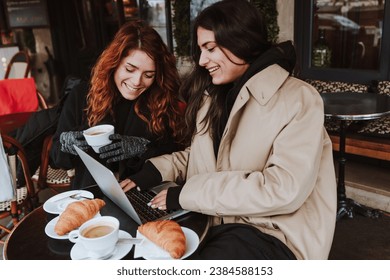 hispanic business couple of women working and using laptop at coffee shop in winter in an urban city in Europe - Powered by Shutterstock