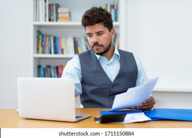 Hispanic Businessman In Quarantine With Computer And Paperwork At Office Or At Home