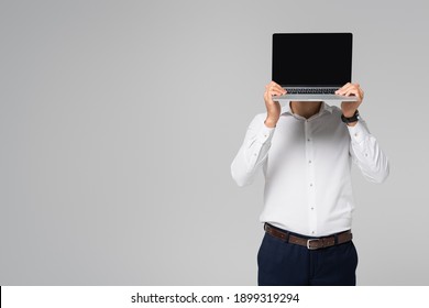 hispanic businessman in white shirt obscuring face with laptop isolated on grey - Shutterstock ID 1899319294