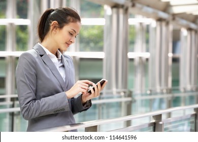 Hispanic Businesswoman Outside Office On Mobile Phone