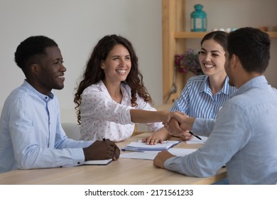 Hispanic ceo shake hands company client after successful negotiations, multi national businesspeople sit at desk making profitable commercial deal feel satisfied. Business meeting, agreement concept - Shutterstock ID 2171561233