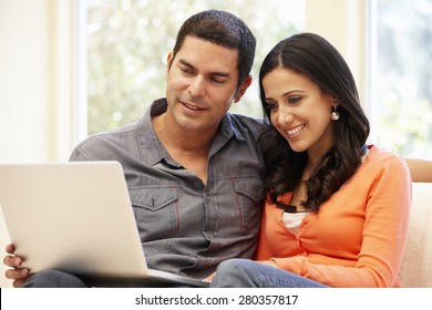 Hispanic Couple At Home With Laptop