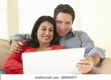 Hispanic Couple Using Laptop At Home