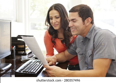 Hispanic Couple Working In Home Office