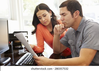 Hispanic Couple Working In Home Office