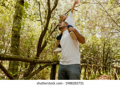 Hispanic Dad Carrying His Daughter On His Shoulders-Family Walking In The Park-Father Having Fun With His Daughter