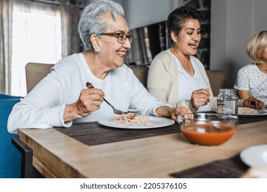 Hispanic Elderly Woman Eating Dinner With Family At Home In Mexico Latin America