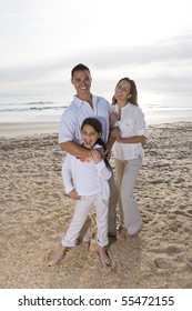 Hispanic Family With 9 Year Old Daughter Standing On Beach