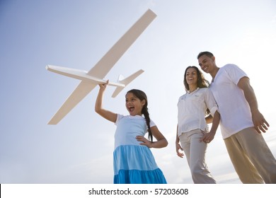 Hispanic family and 9 year old daughter having fun with toy plane