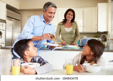 Hispanic Family Eating Breakfast At Home Together