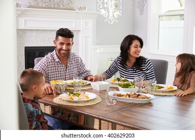 Hispanic Family Enjoying Meal At Table