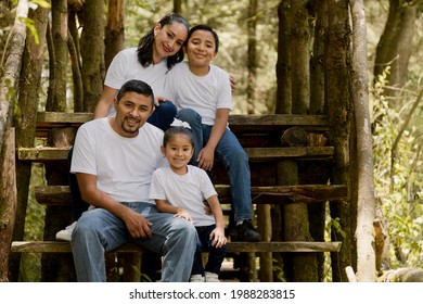 Hispanic family enjoying nature in the park - young parents with their children outdoors smiling at camera - Shutterstock ID 1988283815
