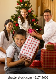 Hispanic Family Exchanging Gifts At Christmas