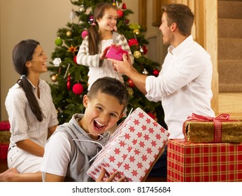 Hispanic Family Exchanging Gifts At Christmas