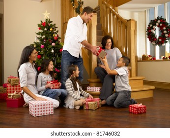 Hispanic Family Exchanging Gifts At Christmas