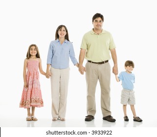 Hispanic Family Of Four Standing Against White Background Holding Hands.