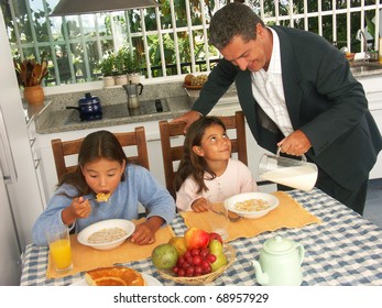 Hispanic Family Having Breakfast In A Kitchen.