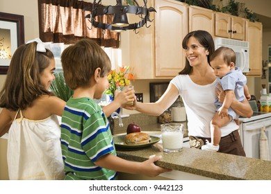 Hispanic Family In Kitchen With Breakfast.