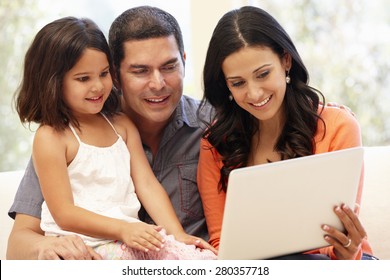 Hispanic Family With Laptop At Home