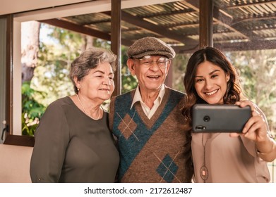 Hispanic Family Making Selfie On Smartphone Posing. Beautiful young woman with her old father and mother. Latin family. - Powered by Shutterstock