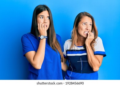 Hispanic Family Of Mother And Daughter Wearing Casual Clothes Over Blue Background Looking Stressed And Nervous With Hands On Mouth Biting Nails. Anxiety Problem. 