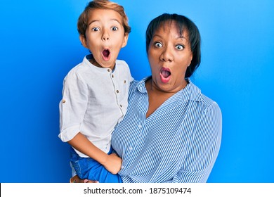 Hispanic Family Of Mother And Son Hugging Together With Love Scared And Amazed With Open Mouth For Surprise, Disbelief Face 