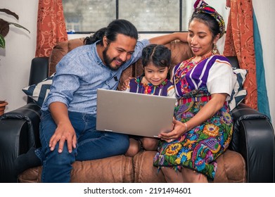 Hispanic Family On The Sofa In Their Living Room .
Mayan Indigenous Family In A Rural Area Use Technology To Educate Their Little Girl.