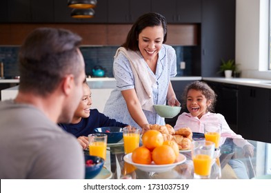 Hispanic Family Sitting Around Table Eating Breakfast Together