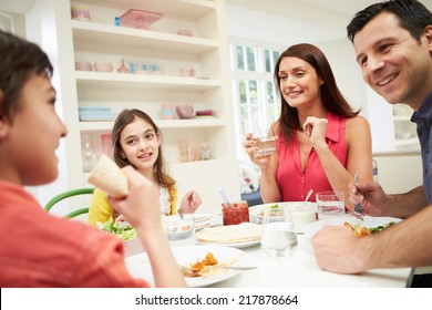 Hispanic Family Sitting At Table Eating Meal Together