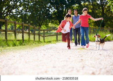 Hispanic Family Taking Dog For Walk In Countryside - Powered by Shutterstock