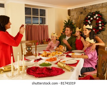 Hispanic Family Taking Photos Of Christmas Dinner