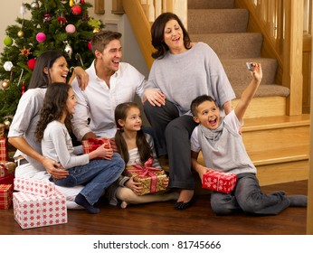 Hispanic Family Taking Photos At Christmas