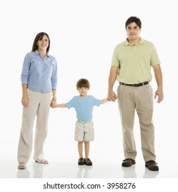 Hispanic Family Of Three Standing Against White Background Holding Hands.