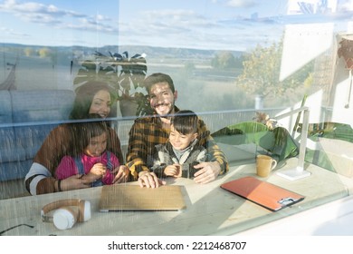 Hispanic Family With Young Children Spend Time Together Sitting On Living Room Couch With Laptop Planning Vacations, Hotel Booking, E-commerce, Apps, Shoppers Choose Online Services