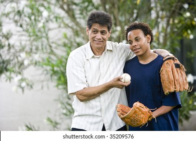 Hispanic Father With African American Teenage Son Holding Baseball And Glove