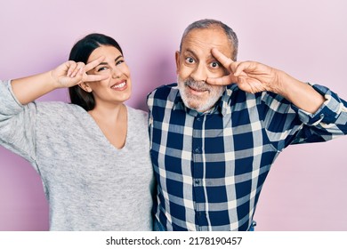 Hispanic Father And Daughter Wearing Casual Clothes Doing Peace Symbol With Fingers Over Face, Smiling Cheerful Showing Victory 