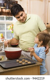 Hispanic Father And Son In Kitchen Making Cookies.