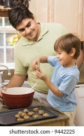 Hispanic Father And Son In Kitchen Making Cookies.