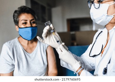 Hispanic Female Doctor Giving Covid Vaccine To Senior Woman In Her Home In Mexico Latin America