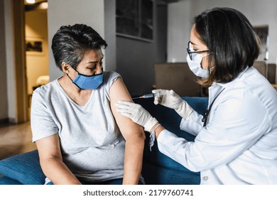 Hispanic Female Doctor Giving Covid Vaccine To Senior Woman In Her Home In Mexico Latin America