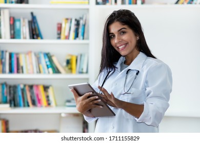 Hispanic Female Medical Scientist With Digital Tablet Researching For Vaccines Against Coronavirus At Hospital