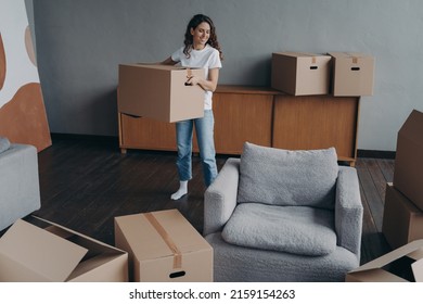 Hispanic Girl Is Holding Box And Leaving Apartment. Happy Young Woman Relocates Alone. Single Lady Moves. Real Estate Purchase, Mortgage, Delivery Service Ordering Concept.