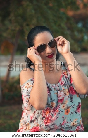 Similar – Woman with sunglasses looking at camera over garden fence