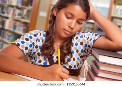 Hispanic Girl Student with Pencil and Books Studying in Library.