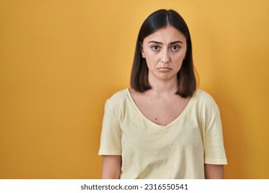 Hispanic girl wearing casual t shirt over yellow background depressed and worry for distress, crying angry and afraid. sad expression.  - Shutterstock ID 2316550541