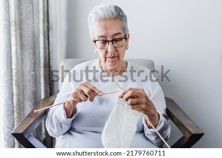 hispanic Grandmother knitting or weaving at home in Mexico Latin America