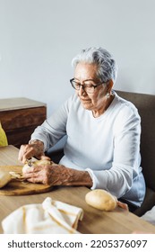 Hispanic Grandmother Peeling Potatoes And Cooking At Home In Mexico Latin America