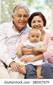 Hispanic Grandparents At Home With Grandchild