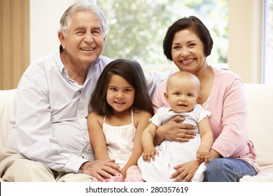 Hispanic Grandparents At Home With Grandchildren